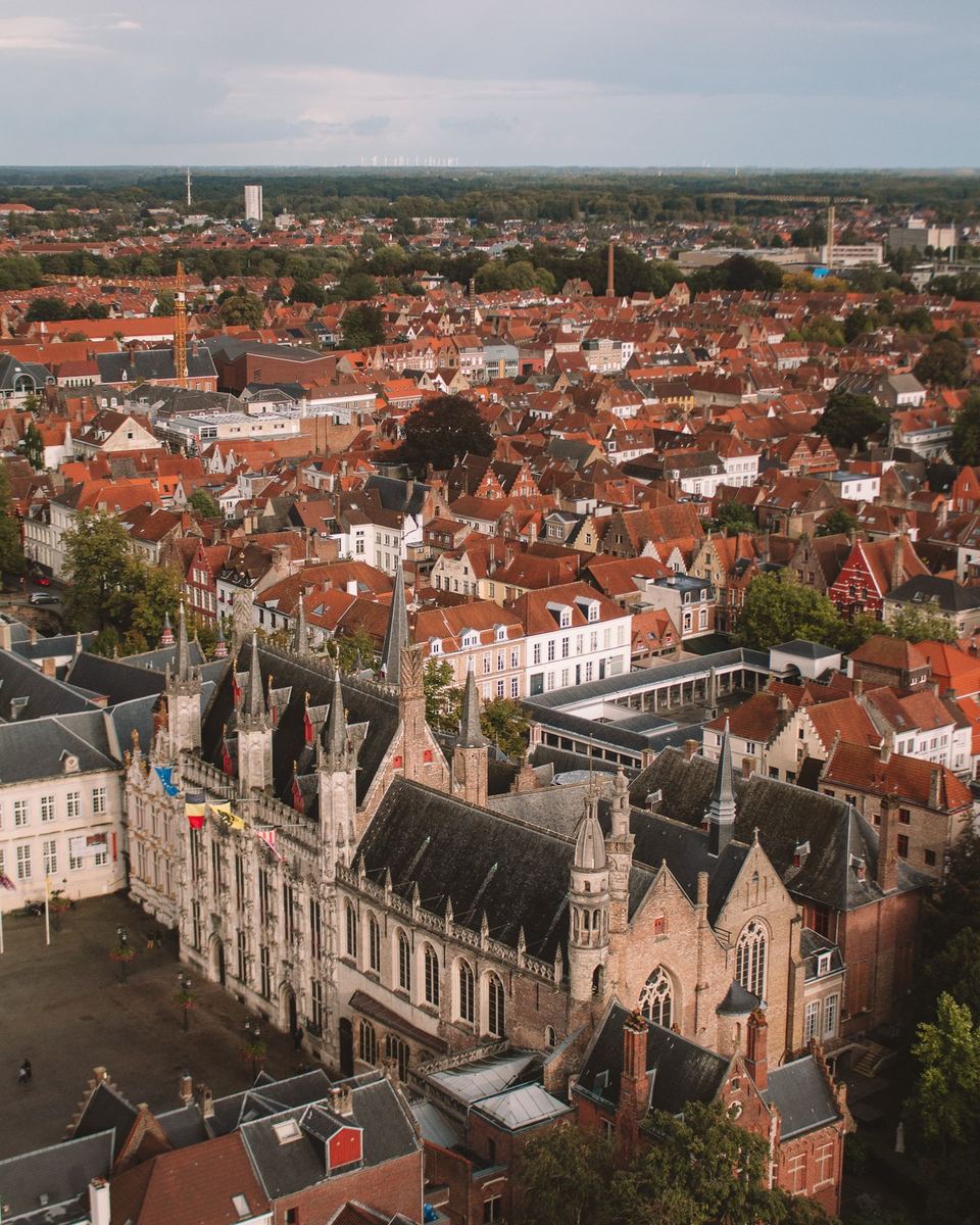 Aerial view over Bruges' red rooftops and spires