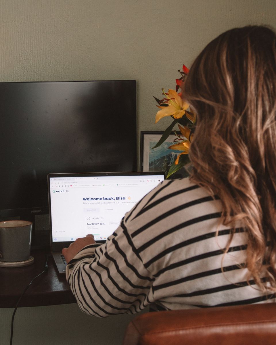 Elise in a striped top working on a laptop at a desk