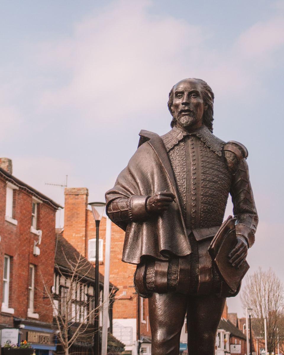 Bronze statue of Shakespeare against a blue sky