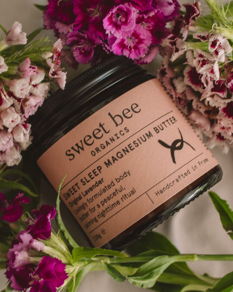 Sweet Bee Organics magnesium butter jar among pink flowers